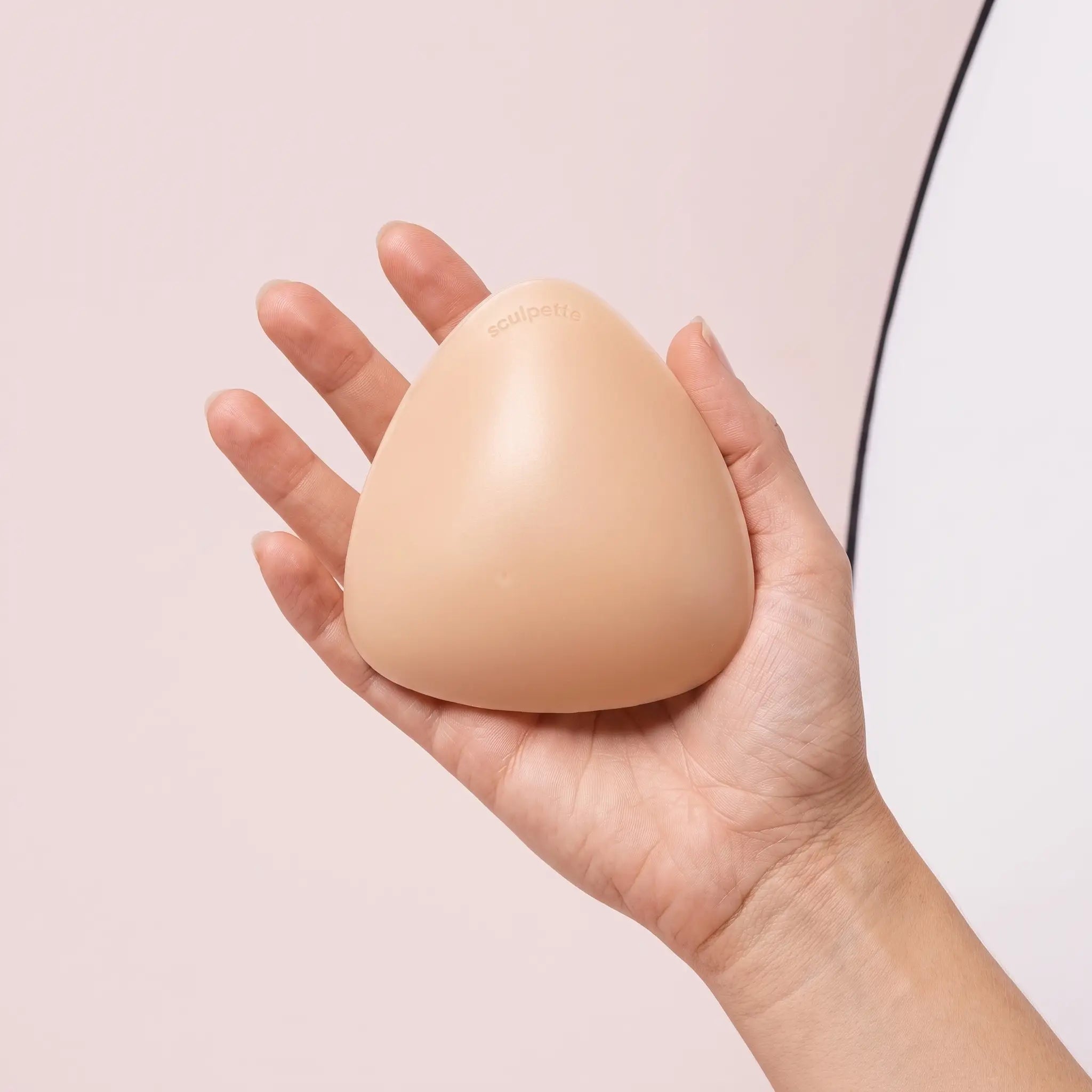 The Sculpt insert resting on an open hand to show its true size