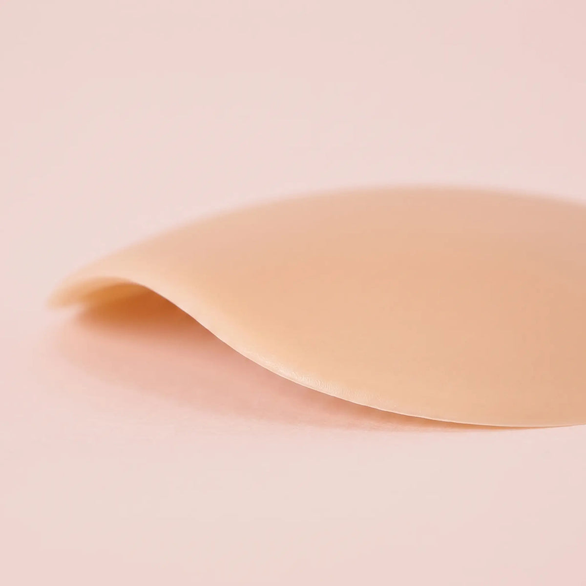 Close-up of The Sculpt Round cover with its feathered edge lifted against the light