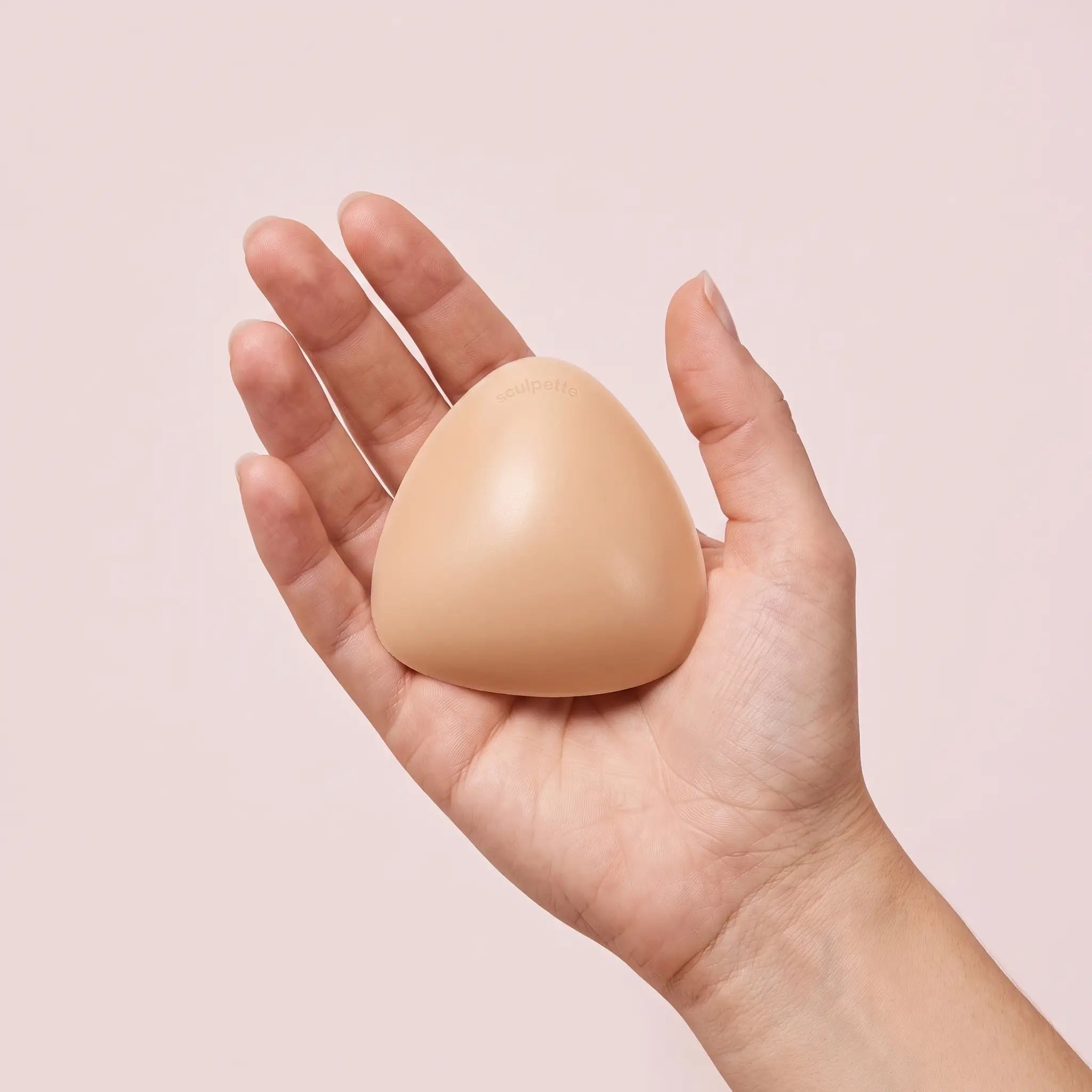 The Sculpt Petite insert on an open hand, clearly smaller than the palm
