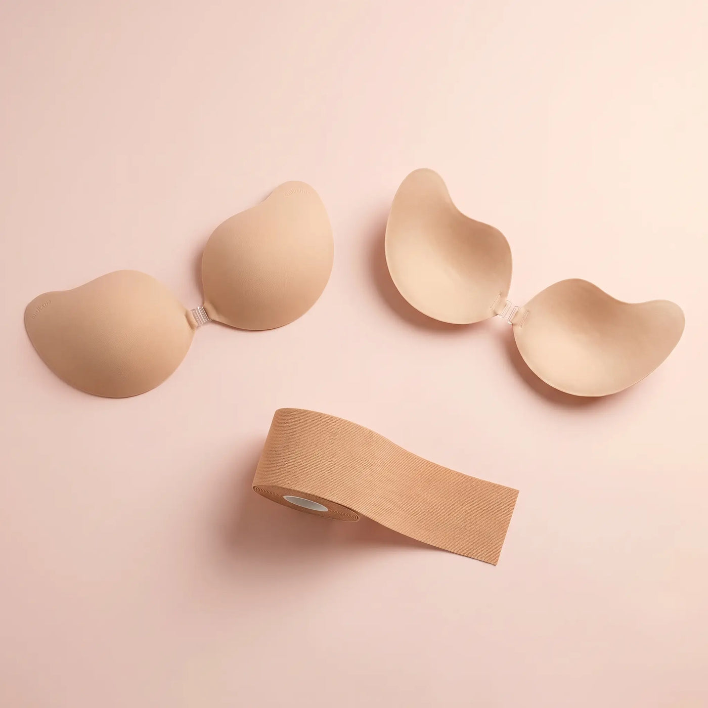 The Strapless Set flat lay - the Statement Bra, the Invisible Bra and a roll of nude body tape