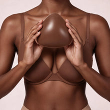 Woman in a nude bra holding a Sculpette adhesive bra insert in Cocoa against her chest