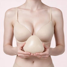 Woman in a nude bra holding a Sculpette adhesive bra insert in Porcelain against her chest